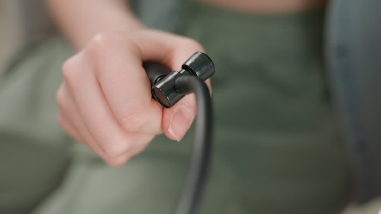 Caucasian woman hand adjusting cuff valve in closeup, firm grip on black connector near tubing, visible manicure and skin texture, precise twist to release pressure, calm empowered selfcare moment
