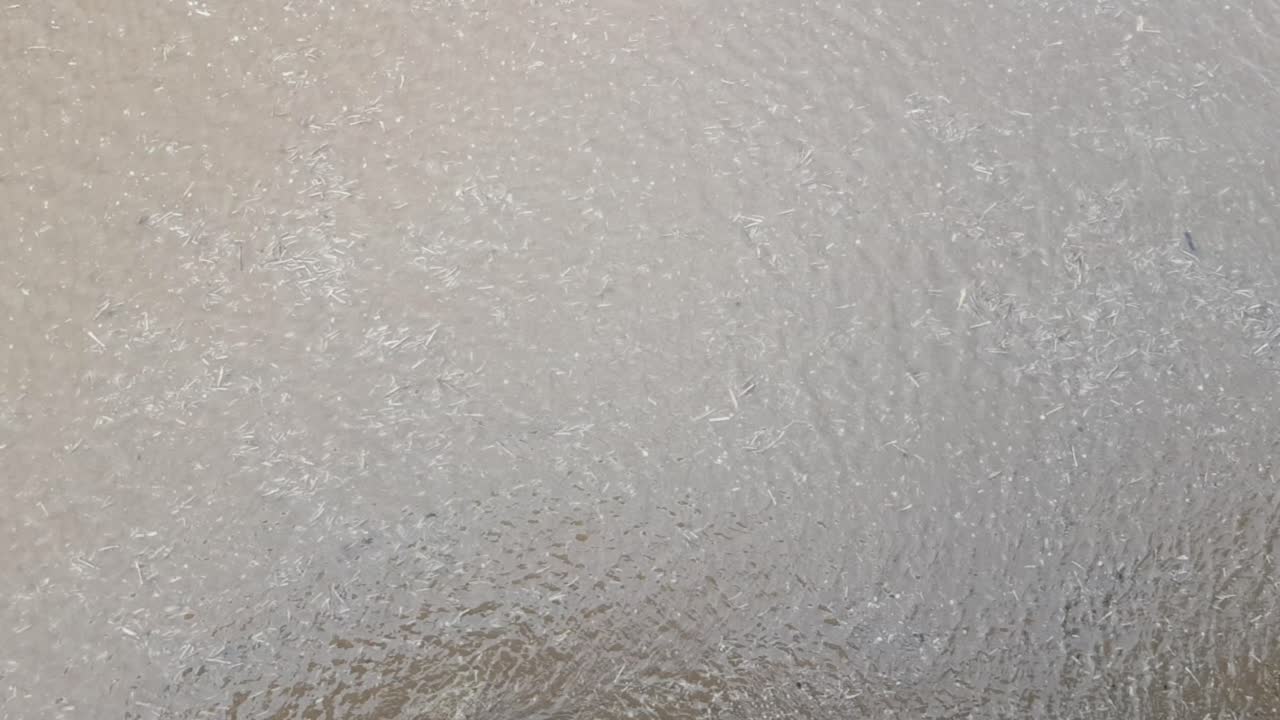 Sea water rippling as wind blows across the surface at the end of the pier as the tide goes out.