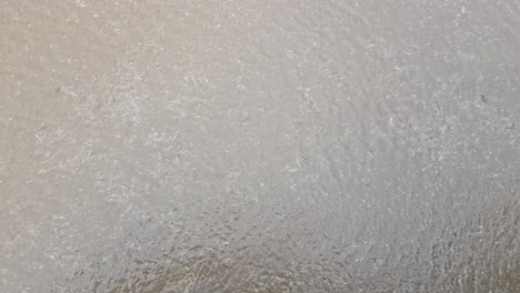 sea water rippling as wind blows across the surface at the end of the pier as the tide goes out.