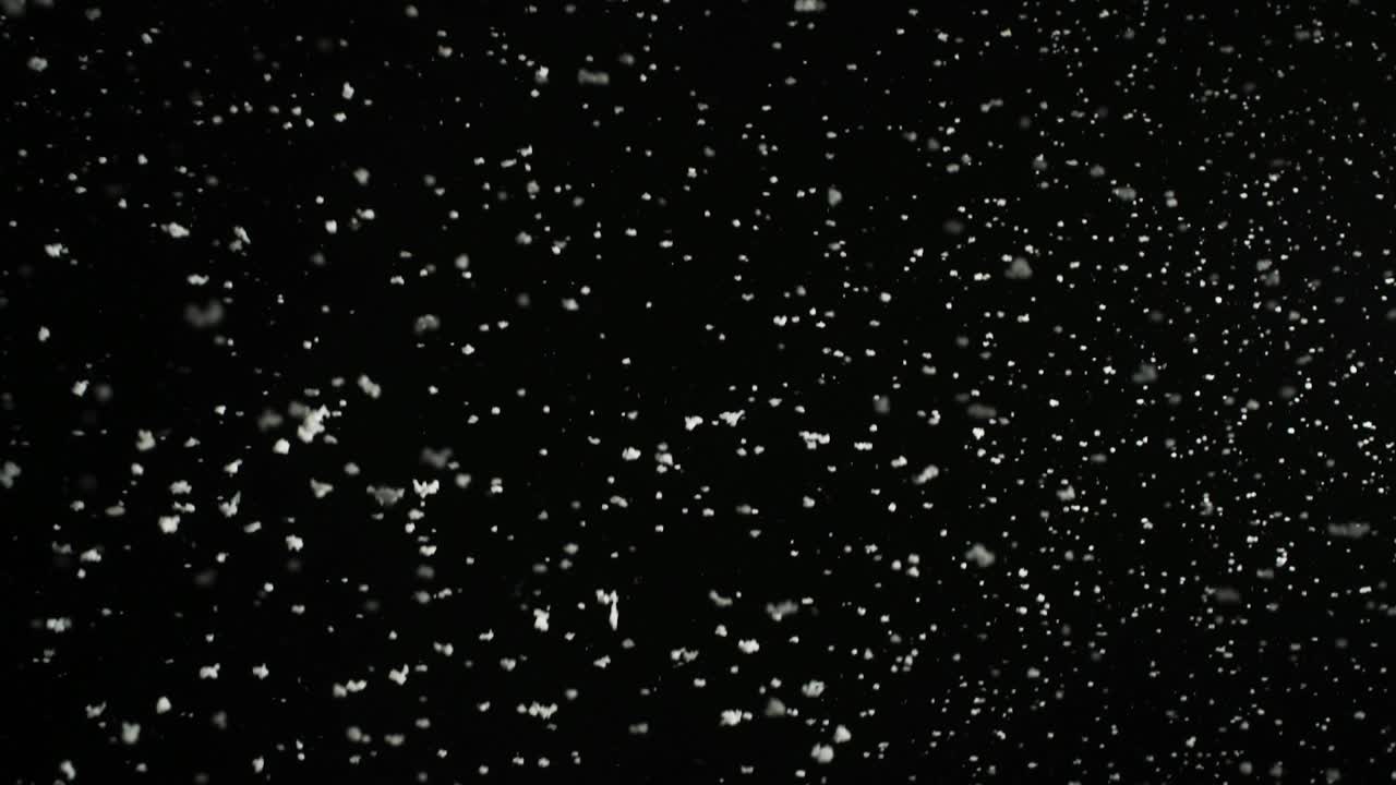Stormfuldt vejr, snefald, store snefnug isoleret på sort baggrund. Ægte linseflare, nem at bruge i blend-/overlay-tilstande.