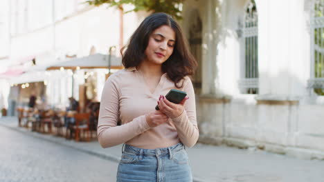 femme utilisant un smartphone envoyant des messages sur les réseaux sociaux à la recherche d'un chemin sur le navigateur carte rue de la ville