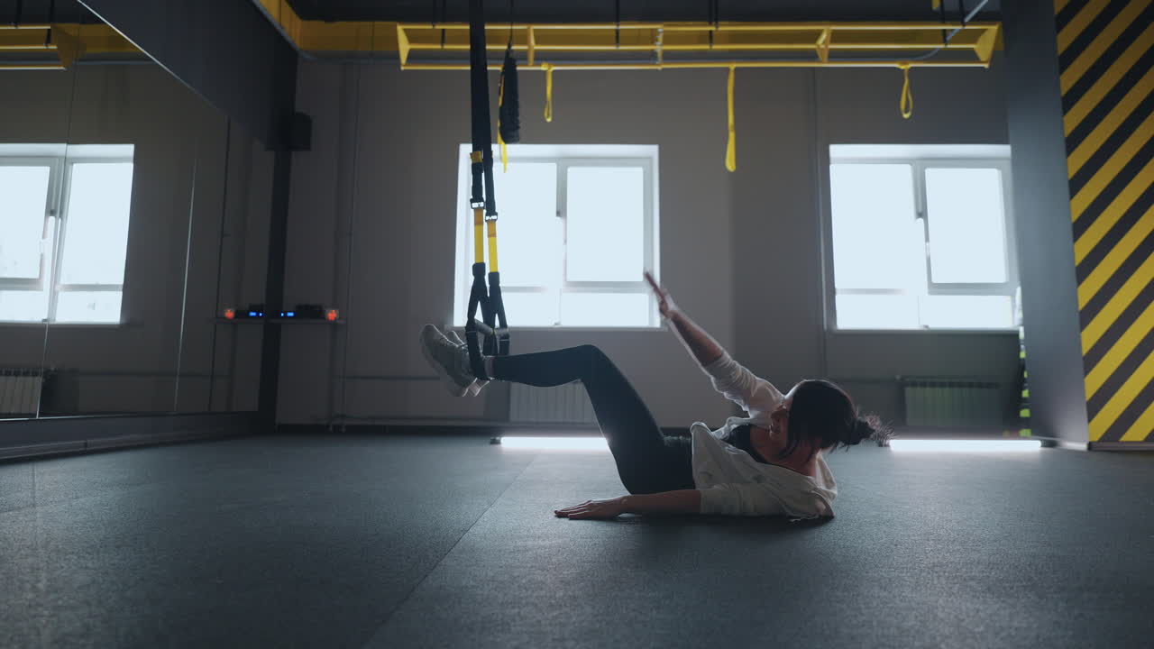 fitness TRX training exercises at gym woman push-up workout. Attractive woman doing exercise for hands in gym. core abs crossfit oblique training with fitness straps in the gym's studio. TRX