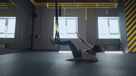 fitness-TRX-training-exercises-at-gym-woman-push-up-workout.-Attractive-woman-doing-exercise-for-hands-in-gym.-core-abs-crossfit-oblique-training-with-fitness-straps-in-the-gym's-studio.-TRX