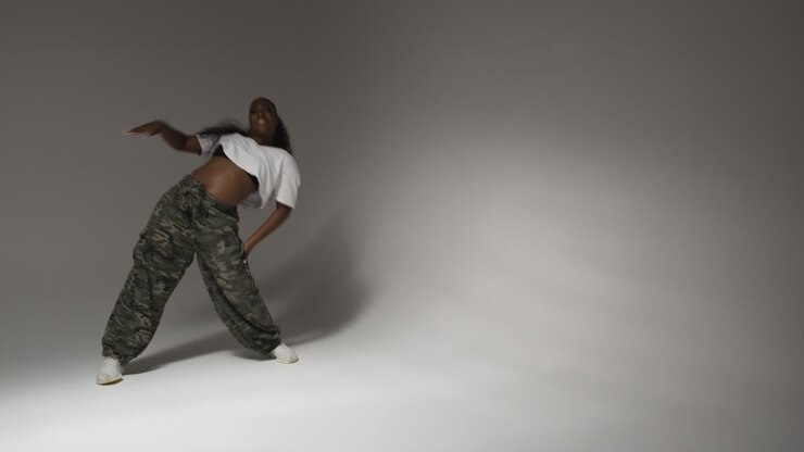 Full Length Studio Portrait Shot Of Young Woman Dancing With Low Key Lighting Against Grey Background 2