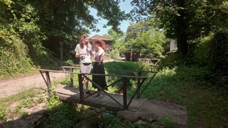 una joven pareja de estudiantes en una puente peatonal rústica visita el romántico pueblo búlgaro de bozhentsi
