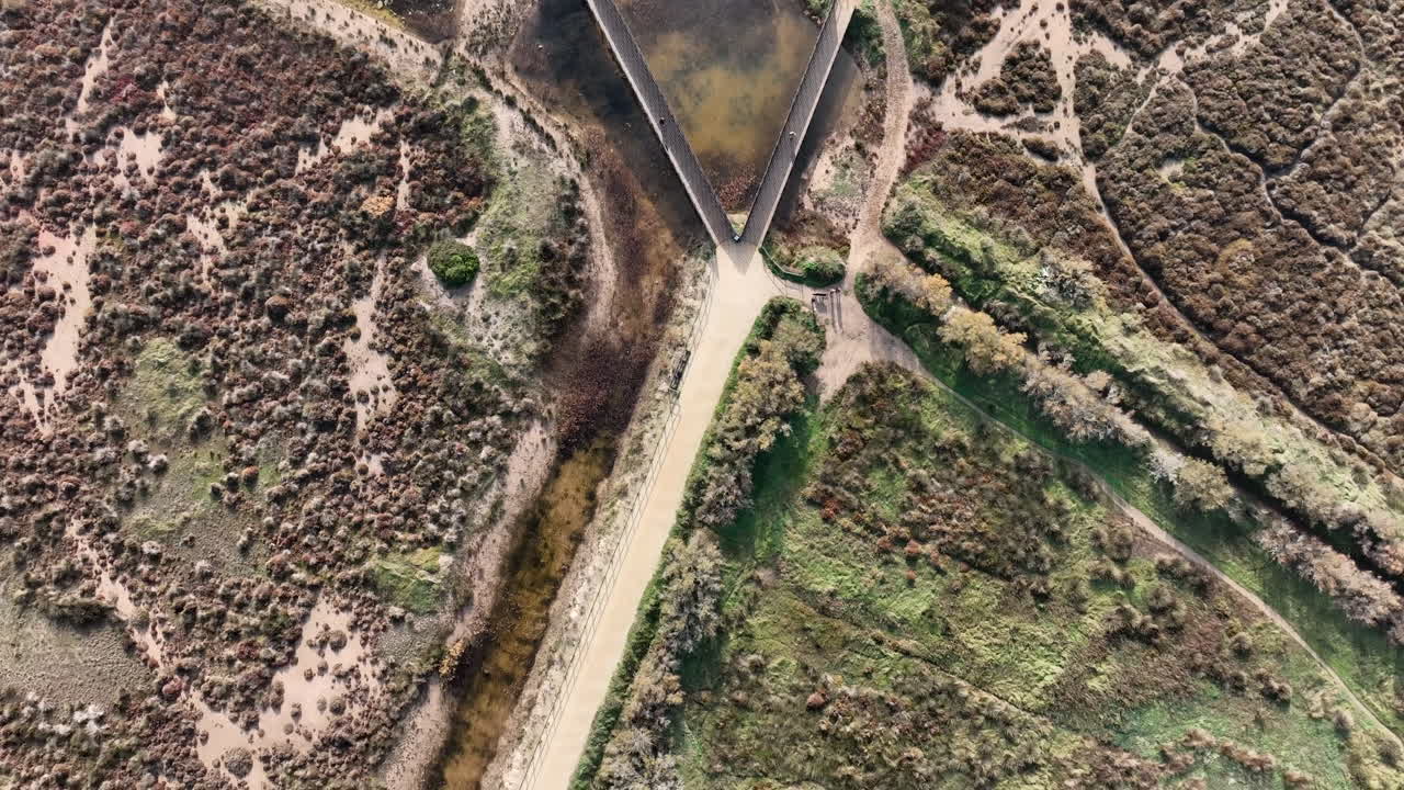 Top down aerial of coastline of Estartit, Costa Brava, tilting above gravel road