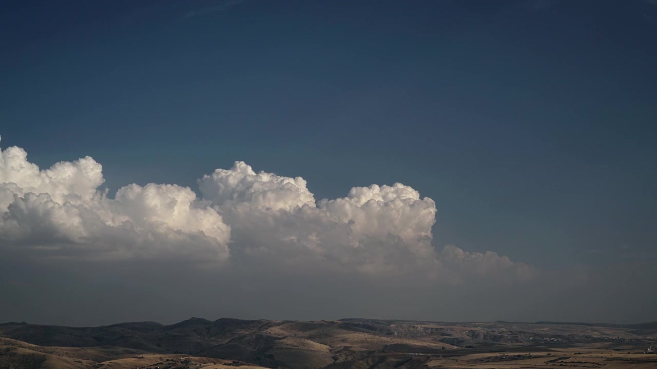 Time-lapse af hvide skyer, der driver over bølgende bakker