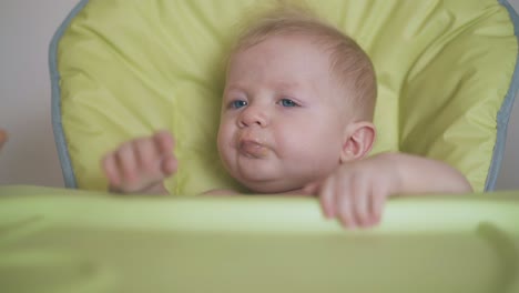 Baby-Isst-Mahlzeit-Mit-Appetit-Und-Sitzt-Im-Hochstuhl-In-Nahaufnahme