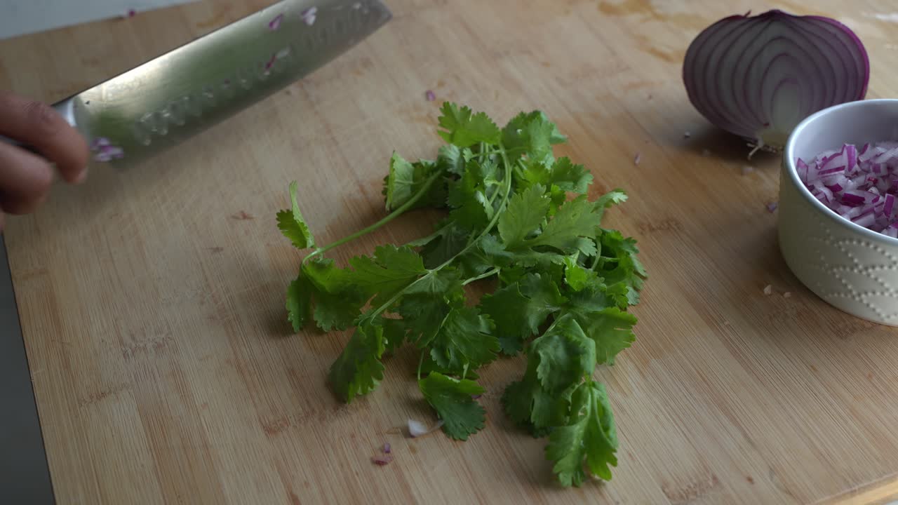 Chopping cilantro and special ingredients to cook a meal two cans of beans rice plantain avocado red onion and cilantro