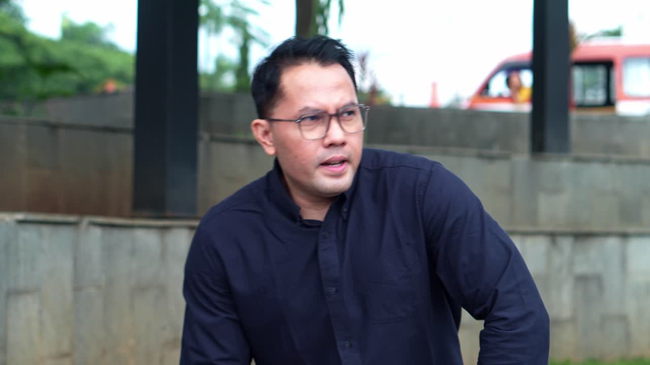 Professional man with glasses presenting idea outdoors engaged and confident expression on face