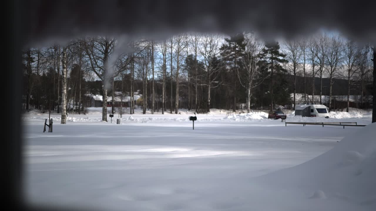 얼어붙은 얼음이 있는 창문에서 겨울의 자연 배경, 눈으로 덮인 들판까지 랙 포커스