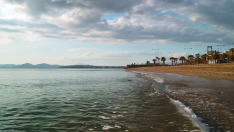 Close-up-aerial-shot-flying-down-a-beach-in-Athens-Greece