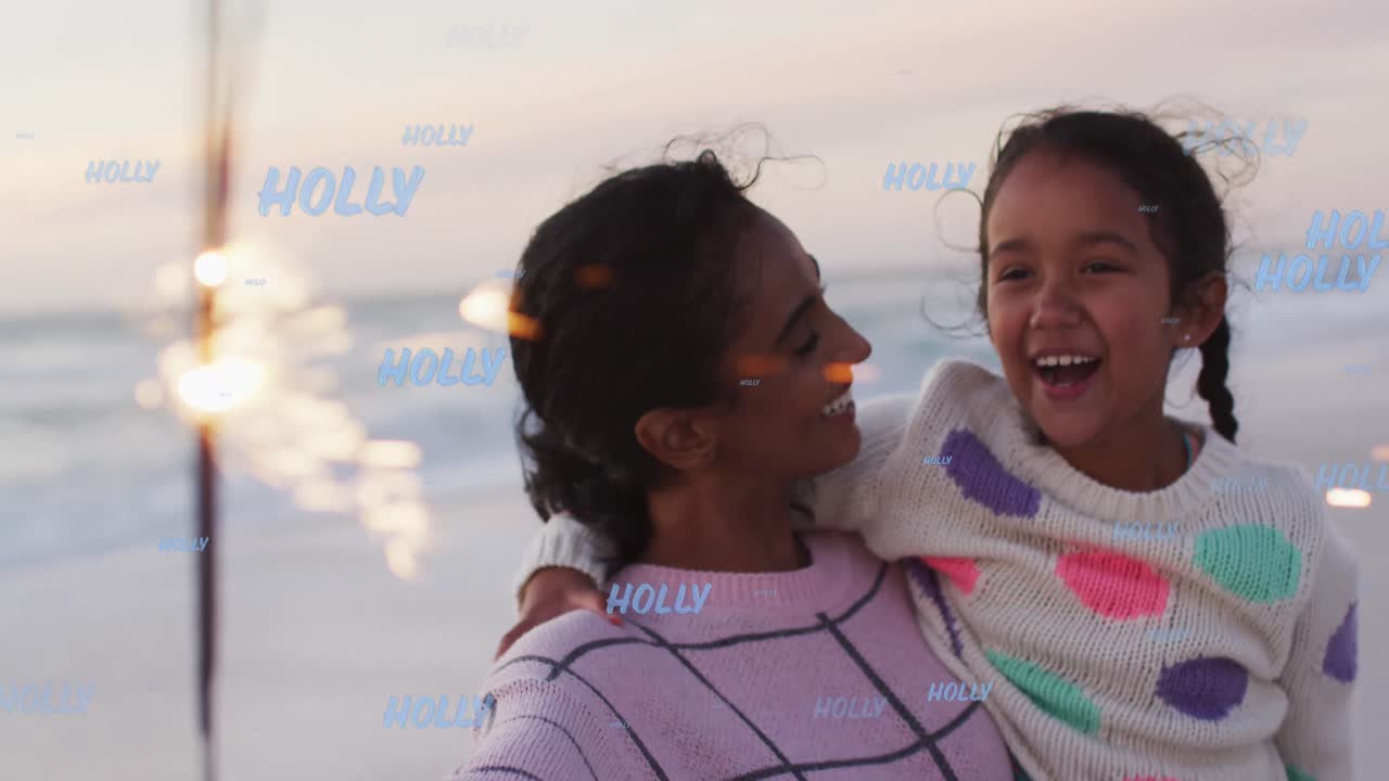 Animation of holly texts over biracial mother with daughter at beach