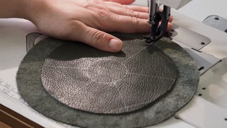 el artesano cose los detalles de la bolsa en la máquina de coser de cerca
