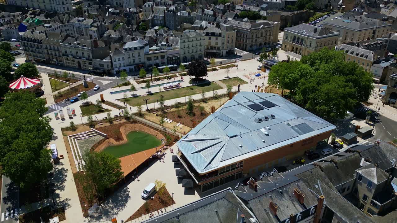 Place du 11 Novembre and modern Halles St Louis in Laval, France, redeveloped public square, carousel. Aerial drone sideways