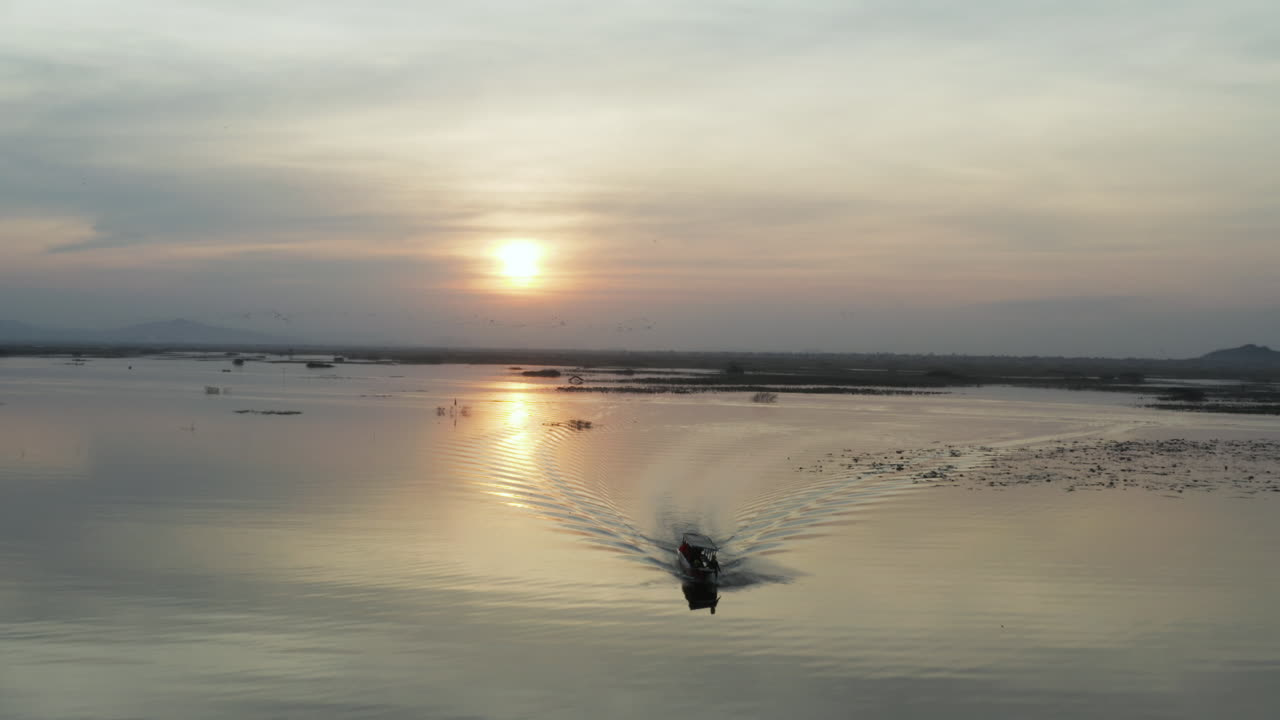 집으로 가는  ⁇ 시 ⁇  배와 날아다니는 새 무리들과 함께 저수지 위의 웅장한 일몰을 밀어