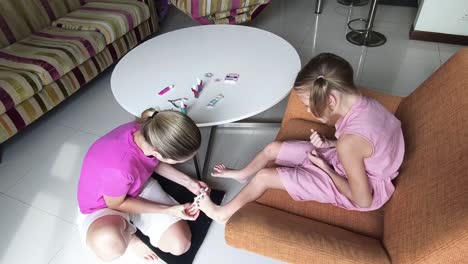 madre haciendo una pedicura a su hija en casa