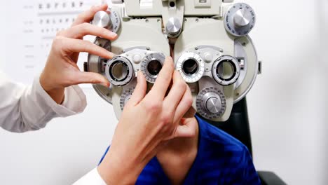 una optometrista examinando a un paciente joven en quiroptero