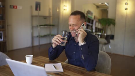 Feliz-Negocio-Animador-Hablando-Por-Teléfono.-Hombre-Recibiendo-Buenas-Noticias-Por-Teléfono-De-Sus-Socios,-Tome-Un-Sorbo-De-Un-Vaso-De-Agua