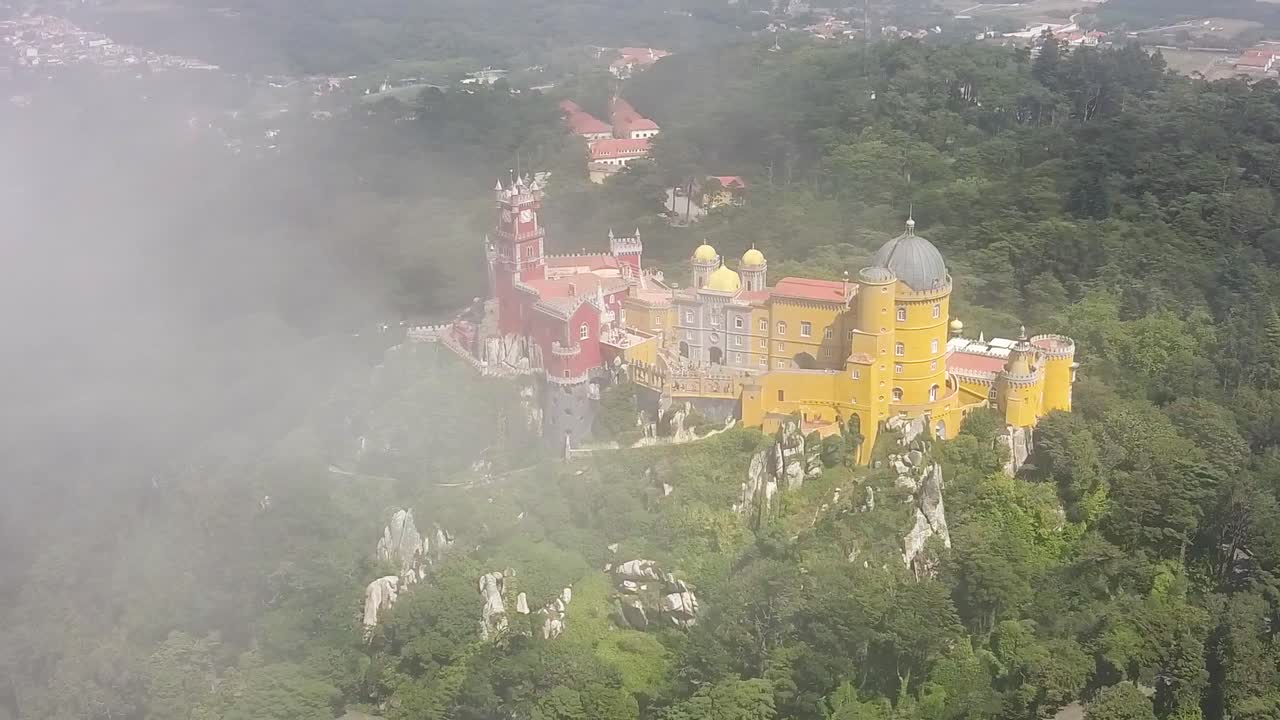 drone aéreo volando a través de las nubes orbitando alrededor del palacio da pena en portugal