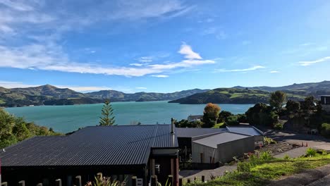 aerial footage captures akaroa's stunning coastal scenery with vibrant blue waters, lush greenery, and clear skies in summer