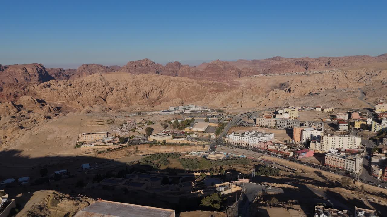 Una ripresa aerea grandangolare che mostra i vasti edifici in pietra di Wadi Musa, la città di accesso all'antico sito nabateo di Petra.