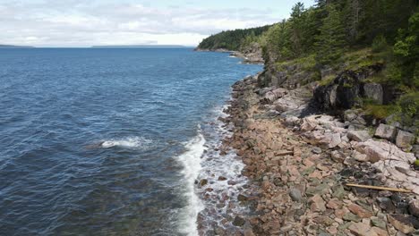 Aerial-flight-along-rocky-coastline-of-Canada-near-Dinner-Rock-during-sunny-day