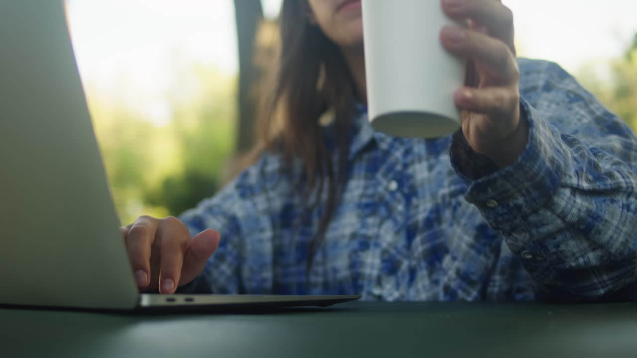Mujer trabajando con laptop en el espacio de coworking del parque verde. Chateando con netbook al aire libre, primer plano.
