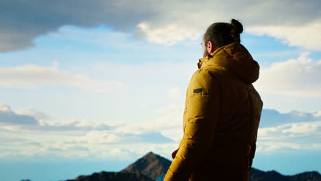 determined trekker looks out at the epic mountain range and sightseeing