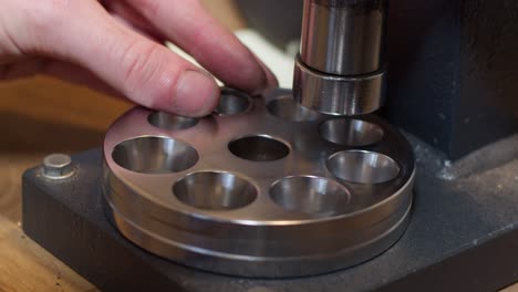 jeweller pressing gold ring in machine in his workshop