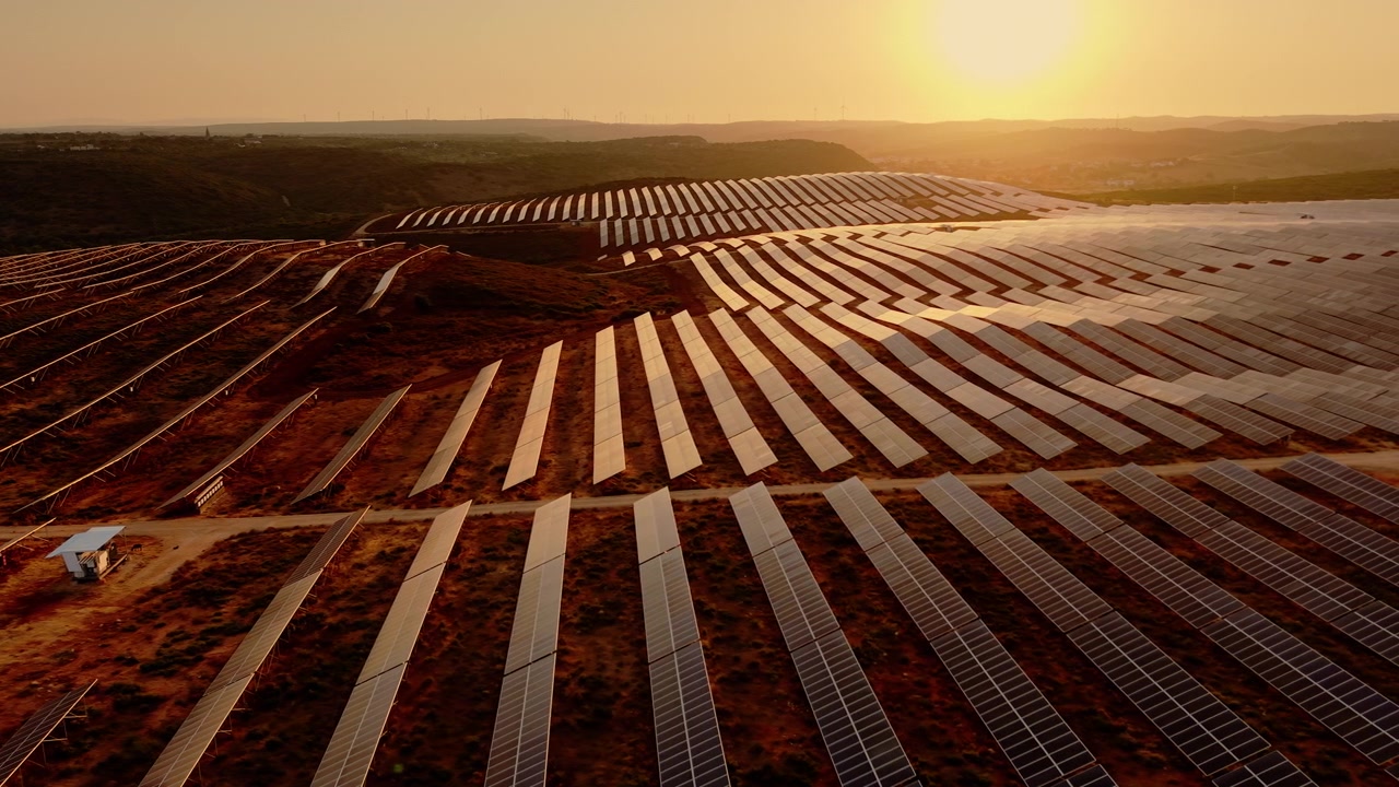 Luftfoto af solpanelpark ved solnedgang
