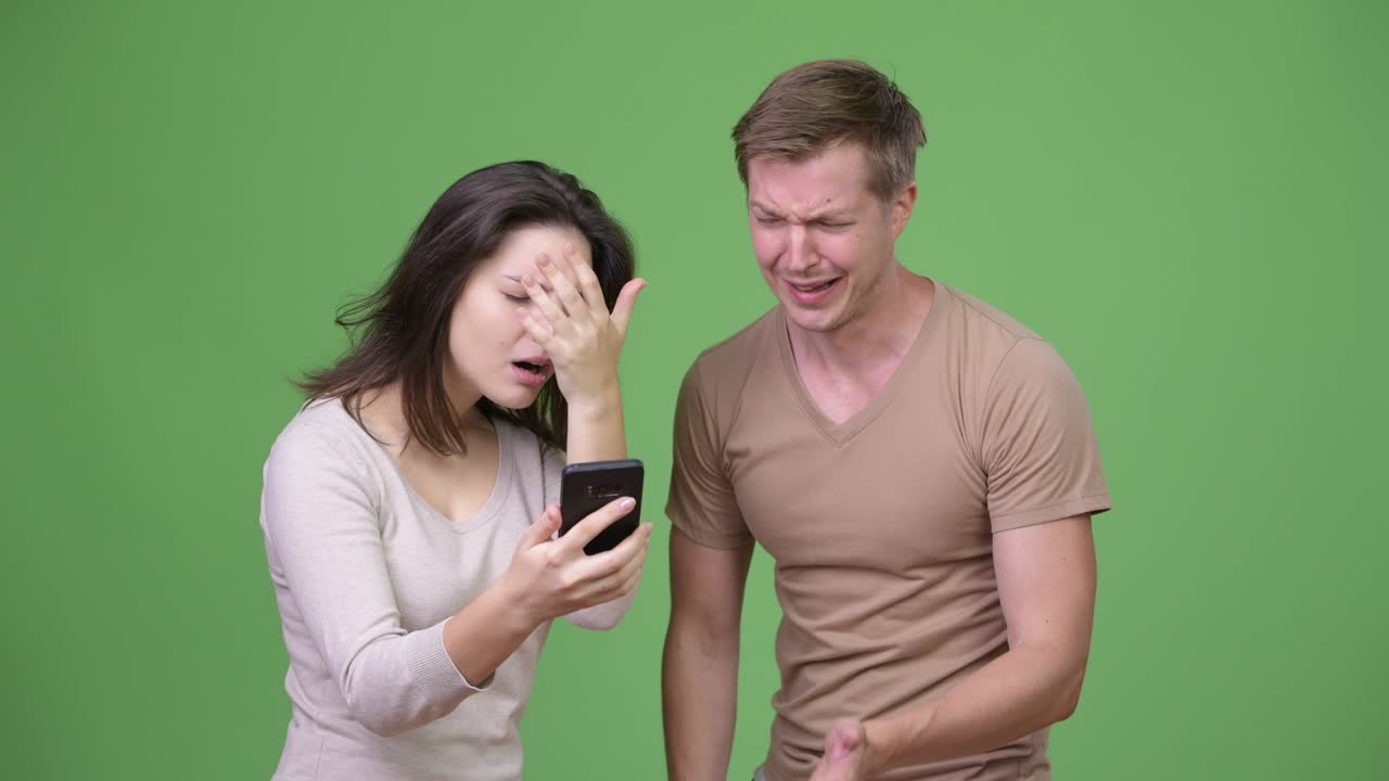 젊은 부부가 함께 전화를 하고 나쁜 소식을 듣고 있습니다.