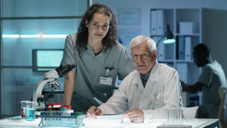 retrato de un científico anciano con una joven asistente femenina en el laboratorio