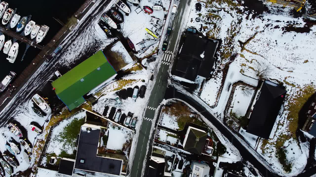 페로 제도에서 눈으로 덮인 항구가 있는 마을이 내려다보이는 드론 샷