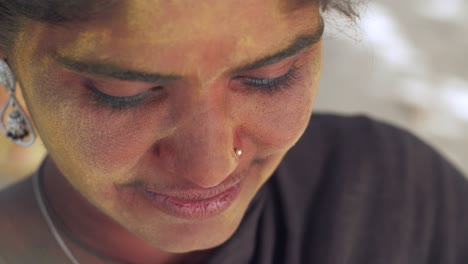 indian women close-up of face smeared with bright holi colors