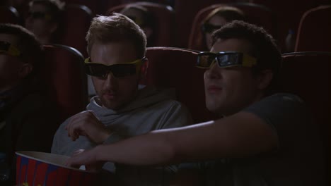 hombre comiendo palomitas de maíz en el cine 3d. los espectadores disfrutan de bocadillos de cine