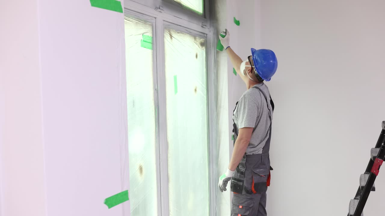 Painter spraying a window