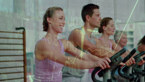 fitness group pedaling on exercise bikes in gym studio, displaying animated performance charts
