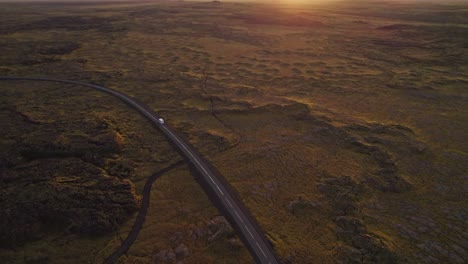 motorhome driving through the volcanic wilderness of iceland at sunset