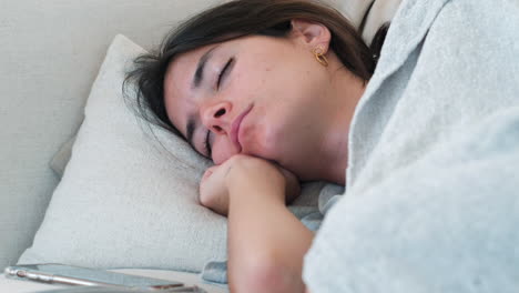 siesta time: close-up of young woman sleeping soundly on couch