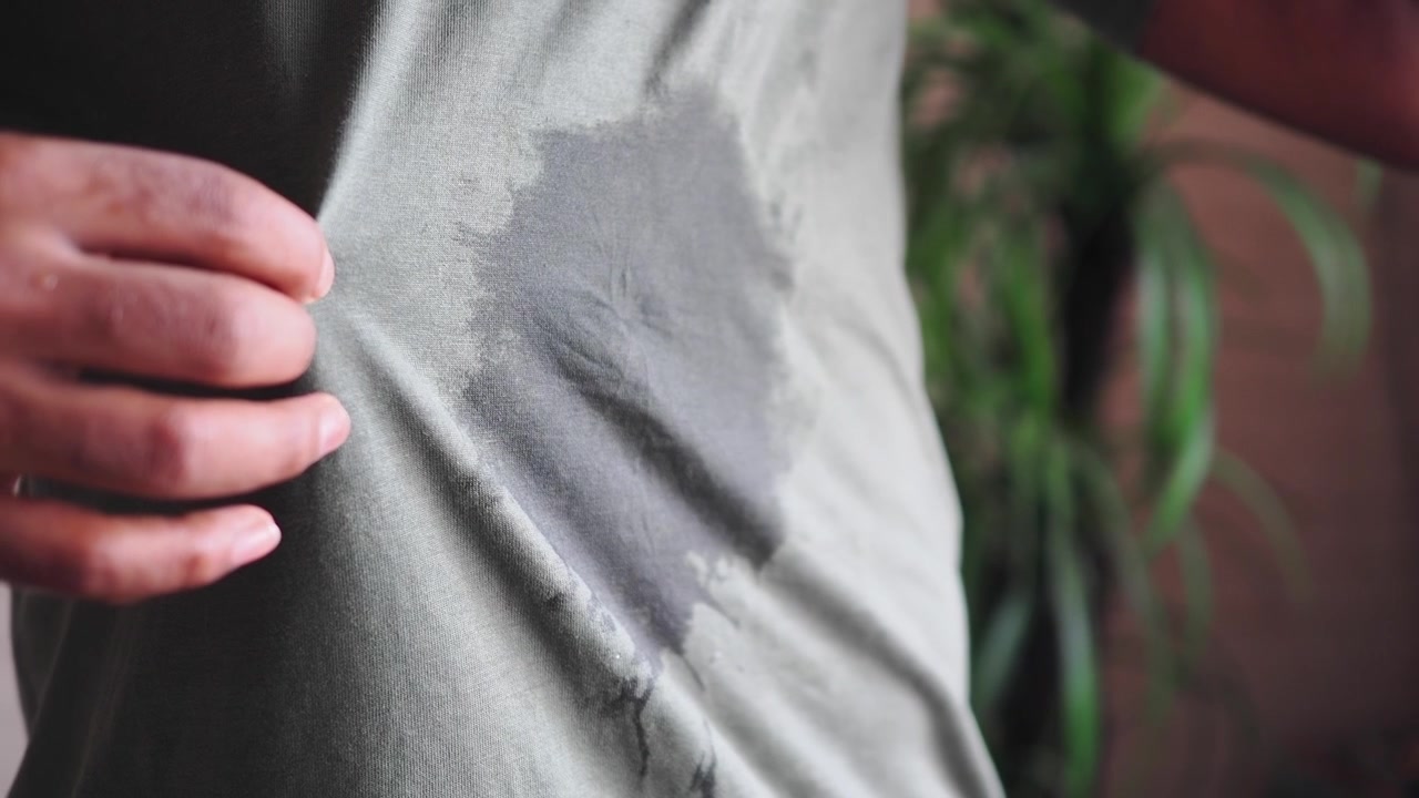 Close-up of a man with a sweat stain on his t-shirt