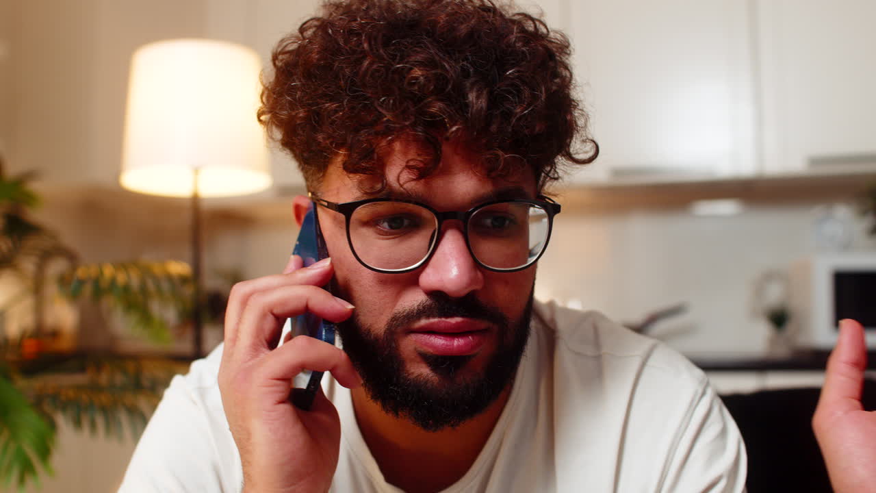 Arabian man refuses spam offer on phone call argues with caller blocks scam number upset indoors mad