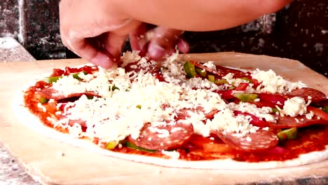 4k footage, close up hand chef putting cheese topping on his pizza base