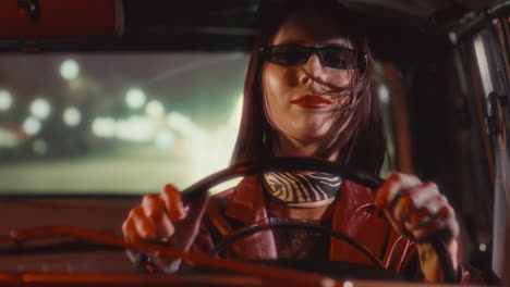 happy woman singing in vintage car during night drive in city