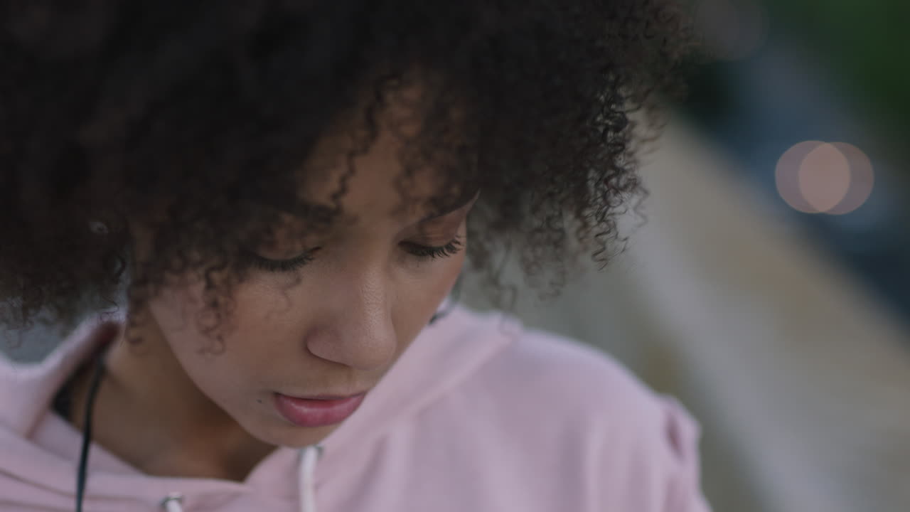 close up portrait beautiful mixed race woman wearing earphones listening to music using smartphone checking messages browsing online smiling happy enjoying mobile communication