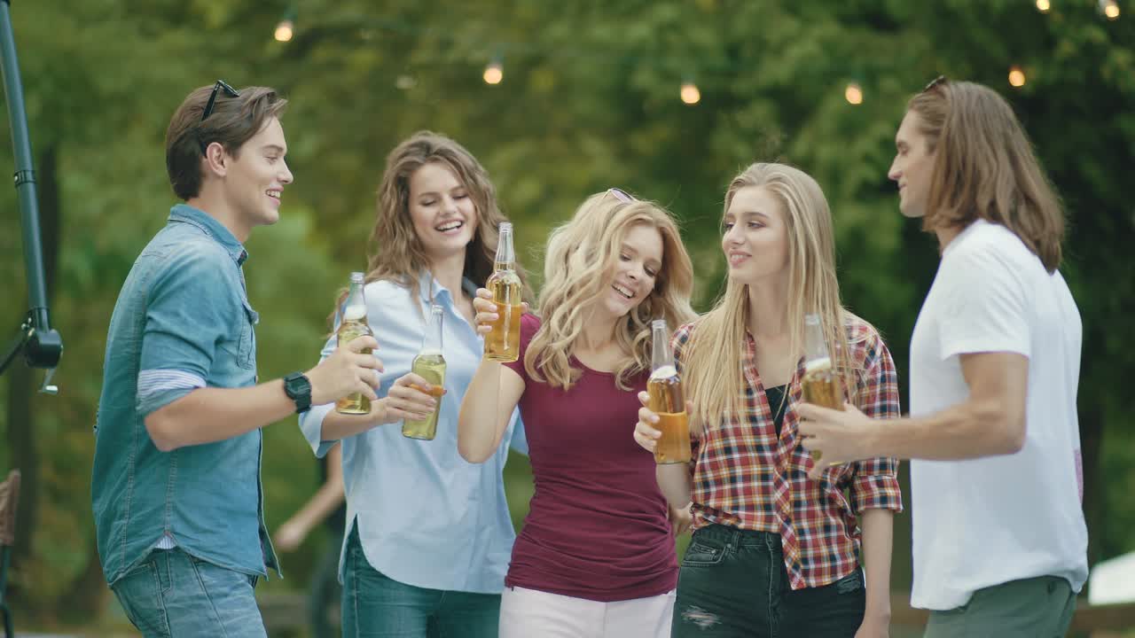 친구들이 재미를 느끼고 맥주를 마시며 술을 마시며 환호합니다.