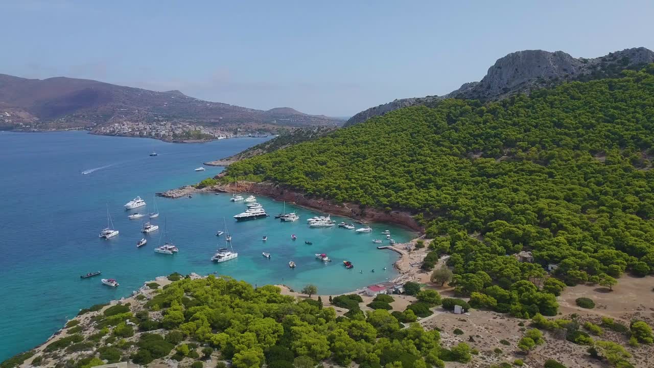 Ascending drone shot of moored yachts and catamarans on a beautiful bay for diving