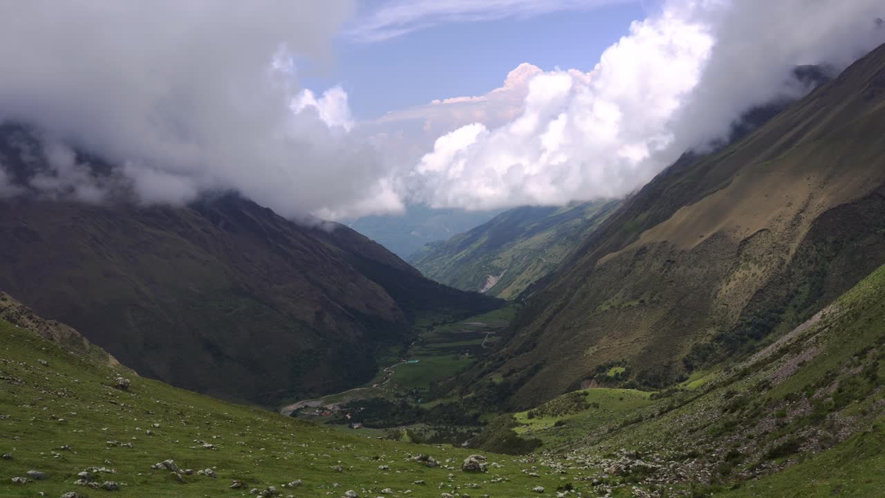 panorámica izquierda del amplio valle verde, colinas cubiertas de bosque con nubes esponjosas arriba