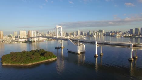 aerial view of rainbow bridge crossing tokyo bay with cityscape of tokyo, japan