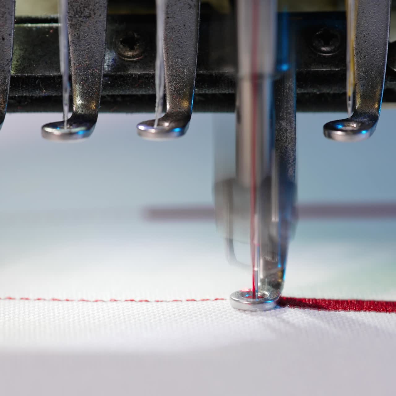 Industria tessile presso un produttore di abbigliamento. Macchina da cucire ricama vari loghi e disegni.